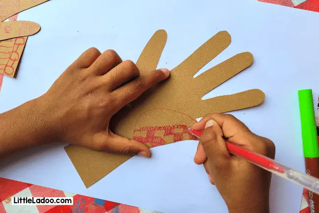 Drawing henna art on handprints